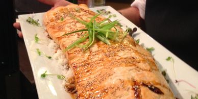 Grilled salmon fillet on a white platter.