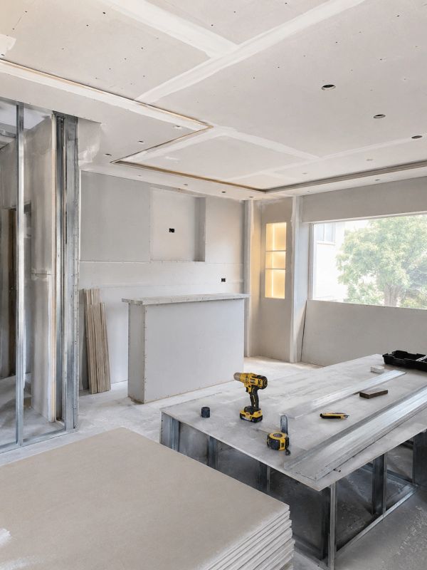 Habitación en construcción con herramientas y drywall.