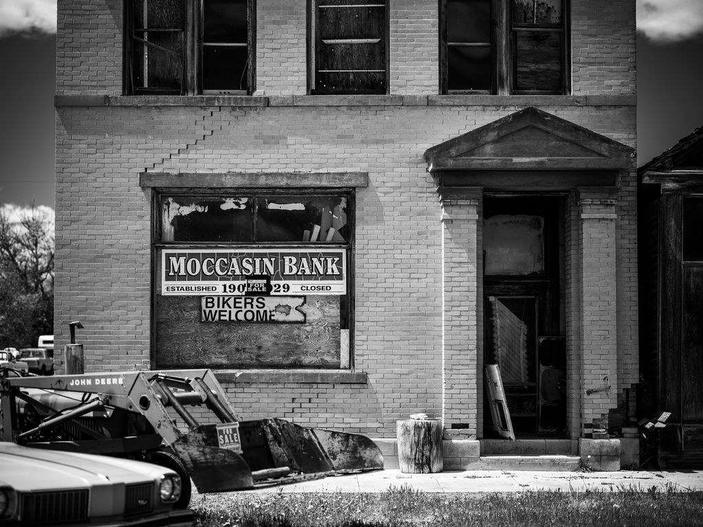 Black and white image of front of old bank with sign saying "Bikers Welcome."