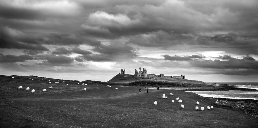 B&W landscape images showing the ruins of Dunstanburgh Castle in Northumberland, UK. 