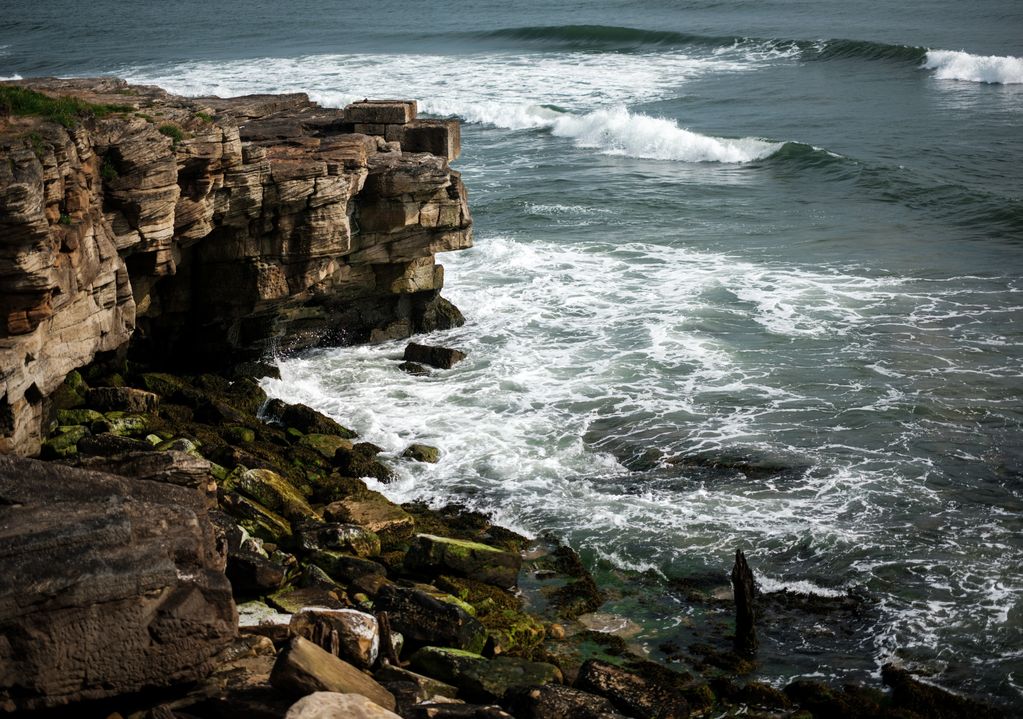 A large rocky shoreline located in north east England is shown as waves of the North Sea. 