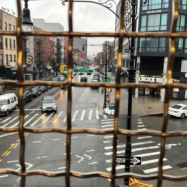 View of city street through rusty wire mesh.