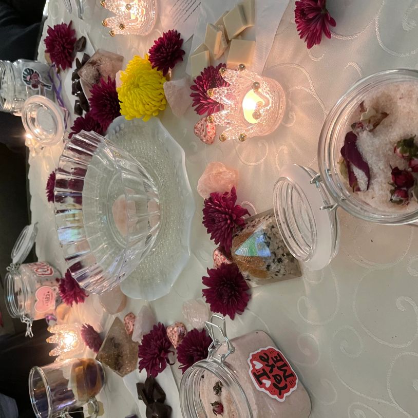 Decorative table setup with flowers, candles, and jars.