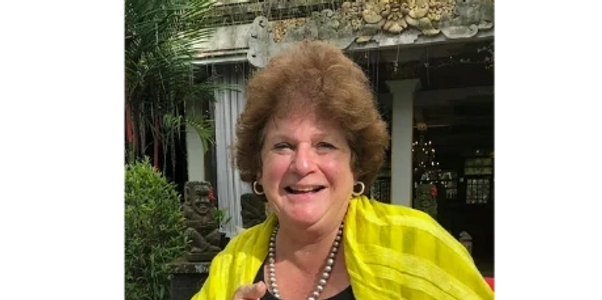 A woman wearing a yellow dress is seen facing forward,