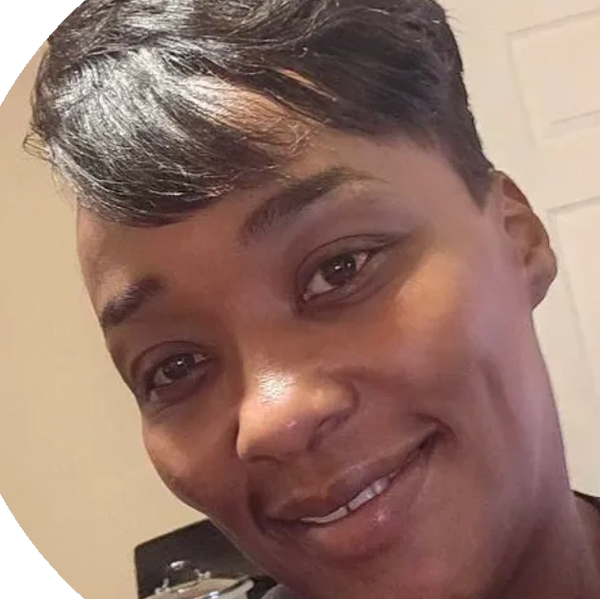 Close-up of a smiling woman with short hair indoors.