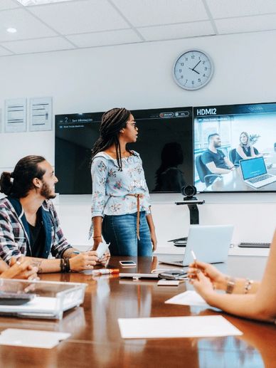 Team meeting with video conference and active discussion.