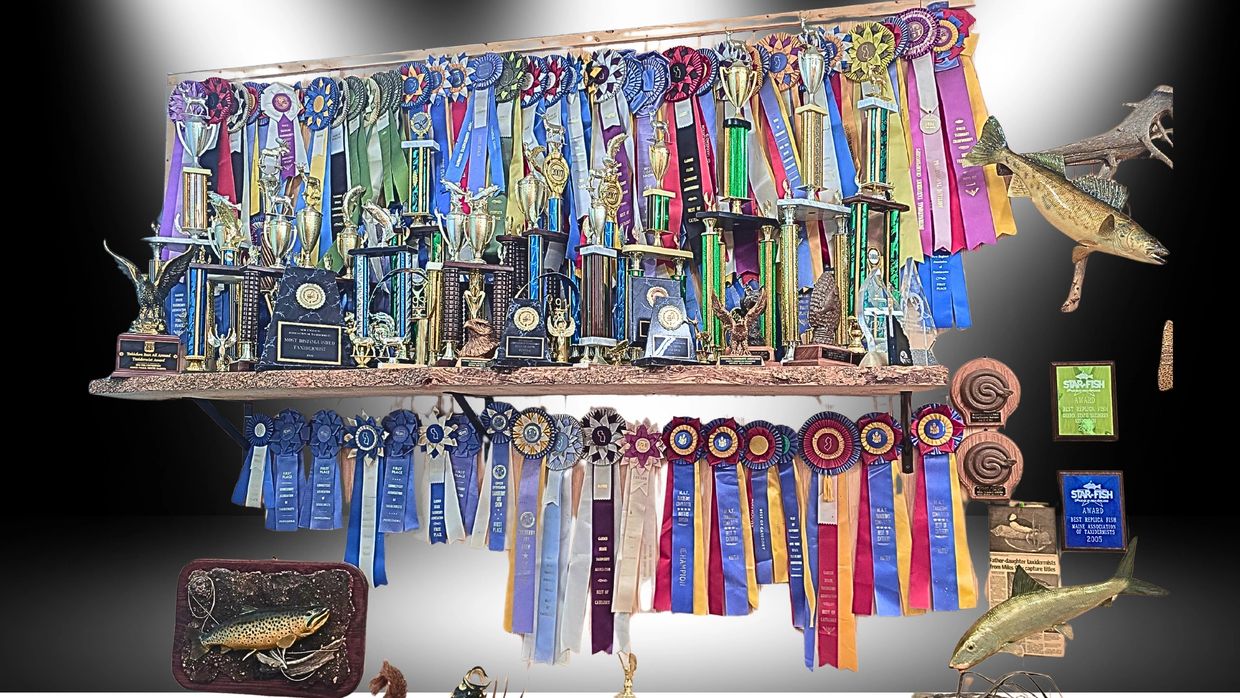 A collection of trophies, ribbons, and plaques showcasing fishing achievements.