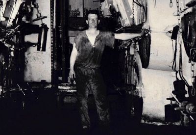 A worker standing inside an industrial facility with machinery.