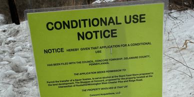 A green sign about a conditional use notice for land development.
