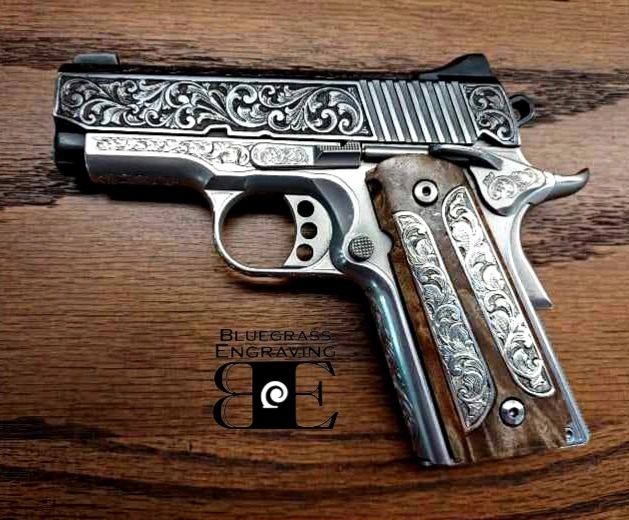 A 1911  model hand gun with silver inlaid grips, and hand engraved scrollwork. 