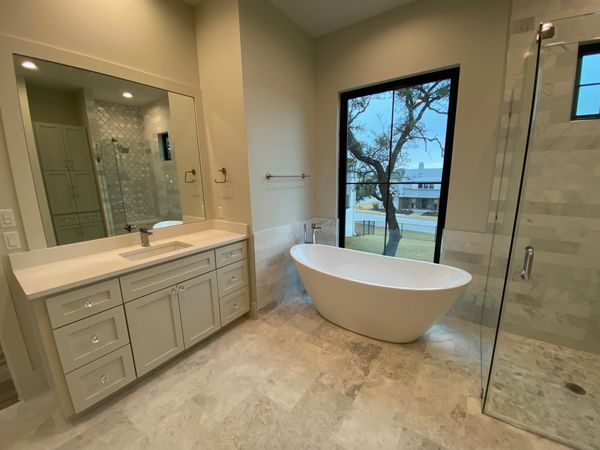 Master bath with Kohler fixtures, freestanding tub, marble floors, and acrylic and brass hardware