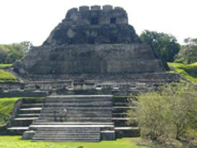 Ancient stepped pyramid with greenery around.