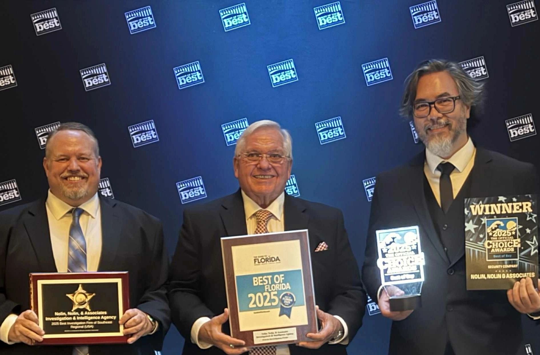 Three men in suits holding 2025 Best of Florida awards at a ceremony.