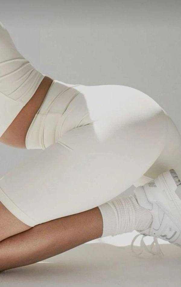 Person wearing white athletic shorts and sneakers in a crouched position.