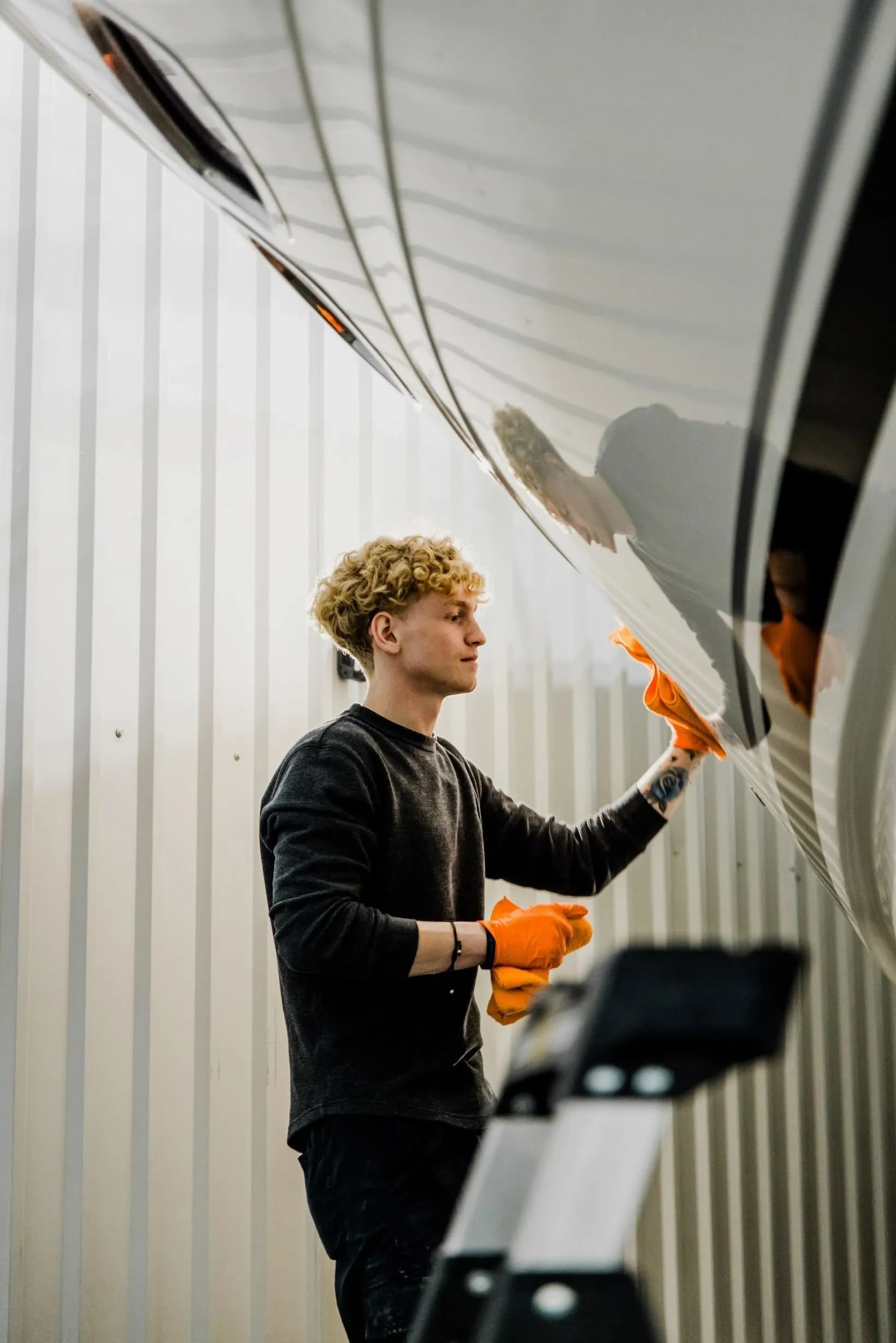 Marine detailing technician polishing boat hull in Grand Haven, MI
