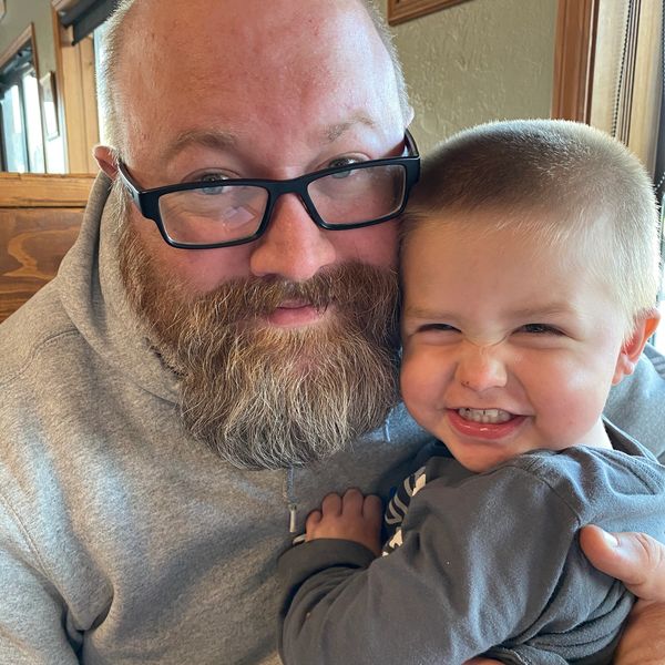 Man and child smiling closely together.