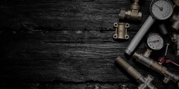 Professional plumbing tools and fittings on a wood floor