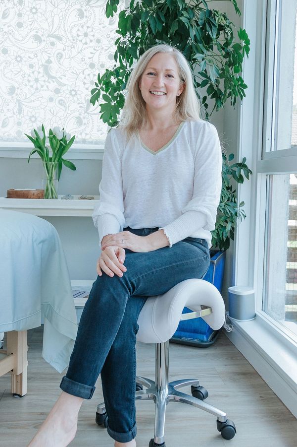 reflexologist smiling sitting in tranquil studio