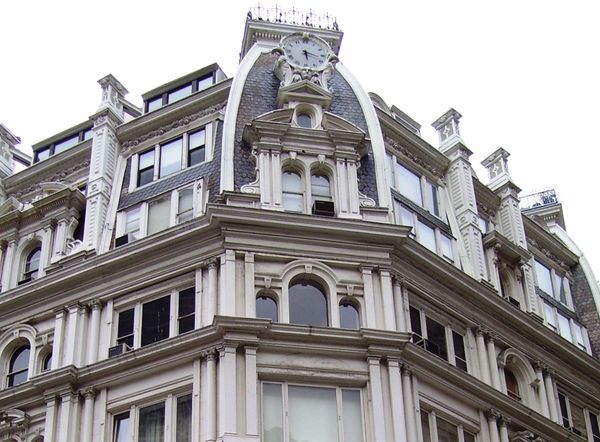 Historic building corner with ornate clock tower and detailed architecture.