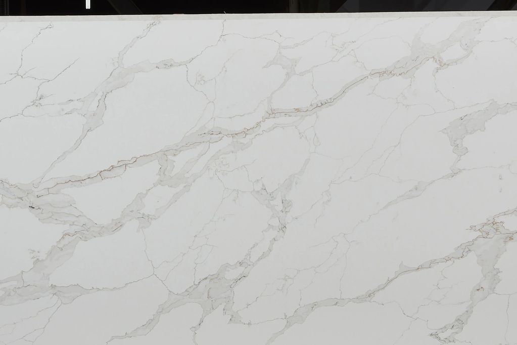 Large white marble slab with grey veining in a warehouse.