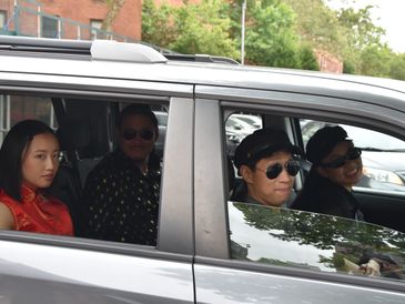 Four cool looking Asian men and girls look out of their SUV