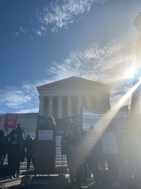 Dr. McHugh speaking to a crowd from a podium in front of the Supreme Court of the United States. 