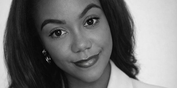Black-and-white close-up portrait of a woman smiling gently.
