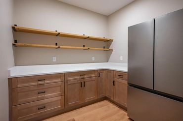 Empty kitchen with wooden cabinets and shelves.