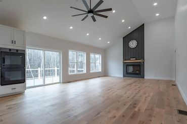 Spacious empty living room with fireplace and large windows.