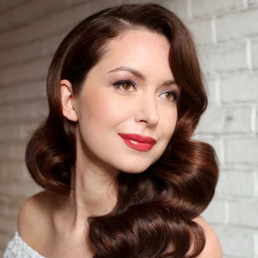 Elegant woman with vintage wavy brown hair and red lipstick.
