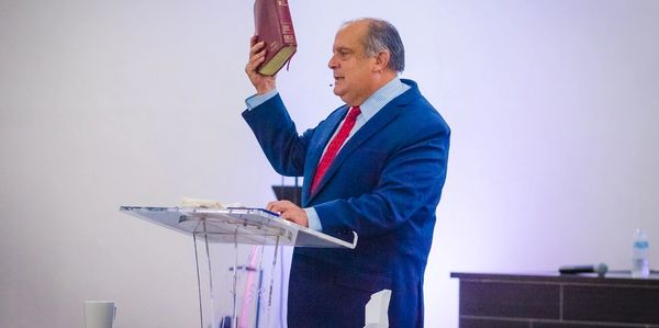 Pastor cristiano evangelico con biblia en su mano derecha vestido formalmente