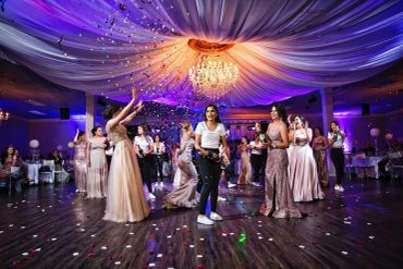 A group celebrating at a decorated indoor event with confetti.