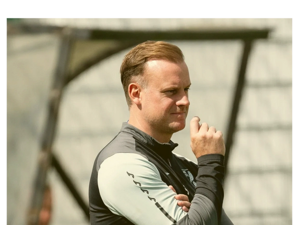 Man in sportswear thoughtfully observing something off-camera.