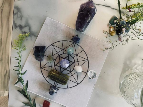 A crystal grid with various stones arranged on a geometric pattern.