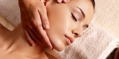 Therapists hands glide gently over clients face in this Lymphatic massage