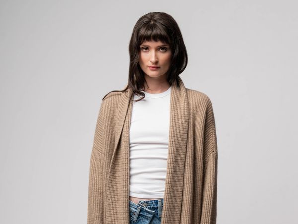 Woman wearing a beige cardigan and white shirt