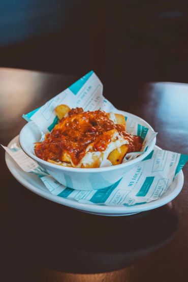 Bowl of fries topped with chili and melted cheese.