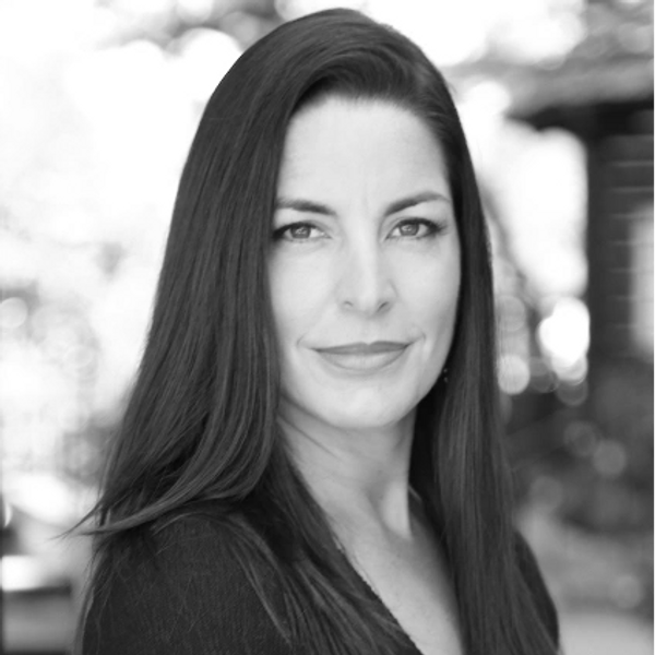 Confident woman with long brown hair posing outdoors.