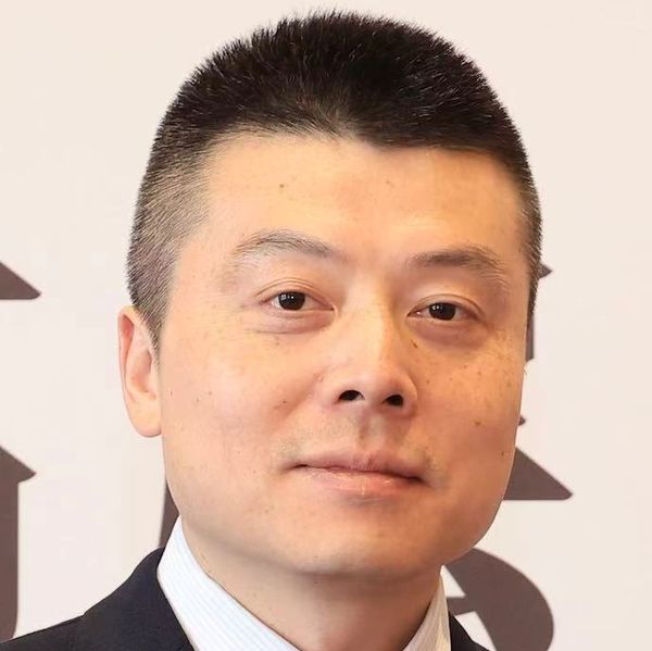 Portrait of a man in formal attire with short hair.