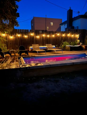 Outdoor Projects: Cozy backyard pool area with string lights and lounge chairs at dusk.