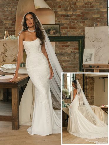 Elegant bride in a strapless fitted wedding gown with a long veil, posing indoors.