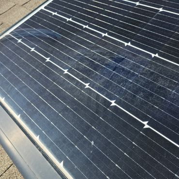 Close-up of a solar panel with visible dirt and smudges on its surface.