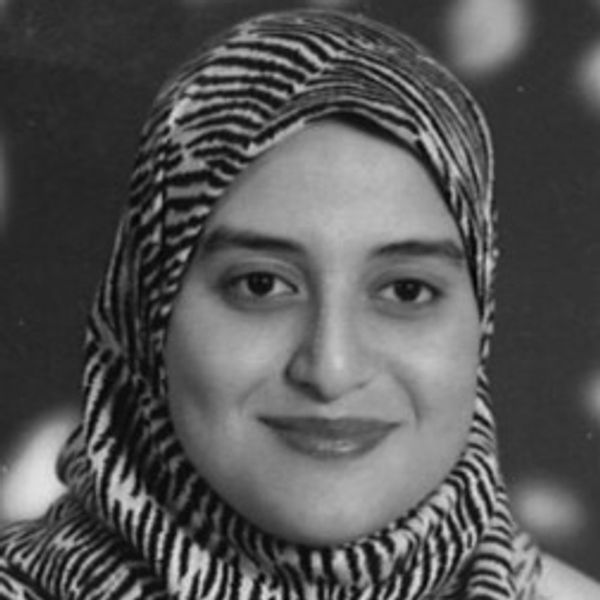 Portrait of a woman smiling, wearing a zebra-patterned hijab.