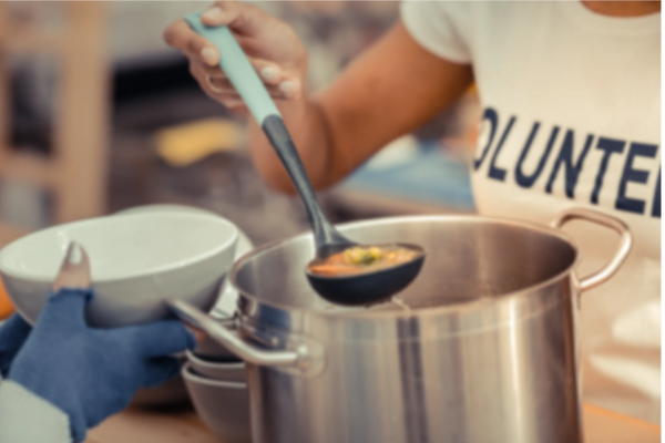 Volunteer Serving Soup out of a pot into a bowl.