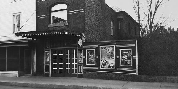 Black and white photo of an old movie theater exterior.