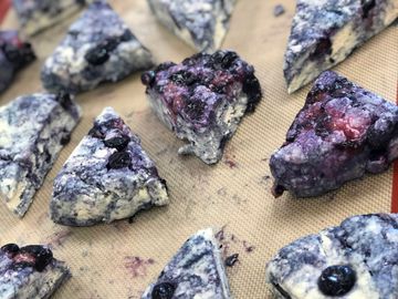 Blueberry butter scones cut and ready to bake on a sheet tray