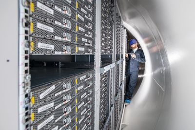 Technician inspecting servers in a data center.