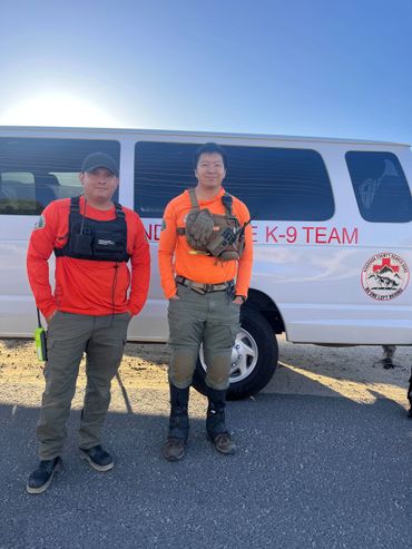 Two K-9 team members standing in front of their team van.