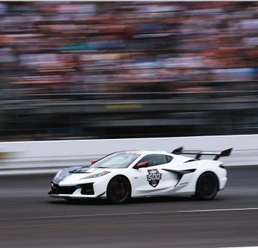 White sports car speeding on racetrack.