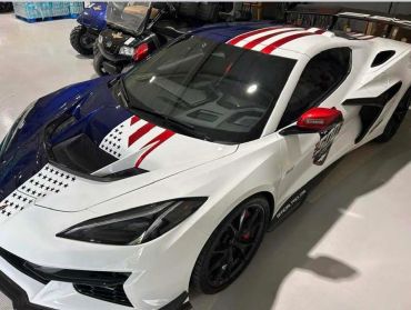 A sports car with a patriotic American flag paint design.